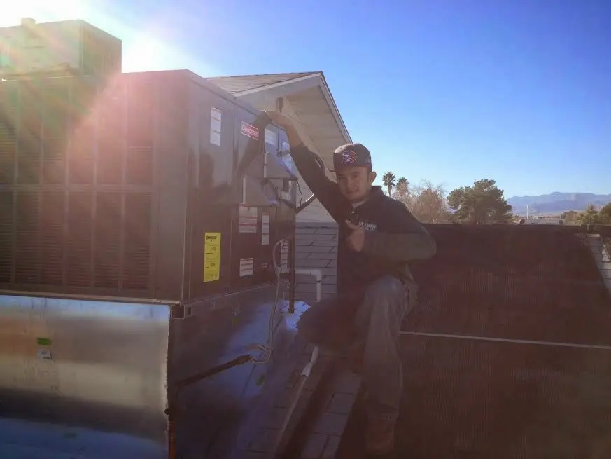 HVAC technician performing AC Tune-Up on a rooftop unit in Waverly