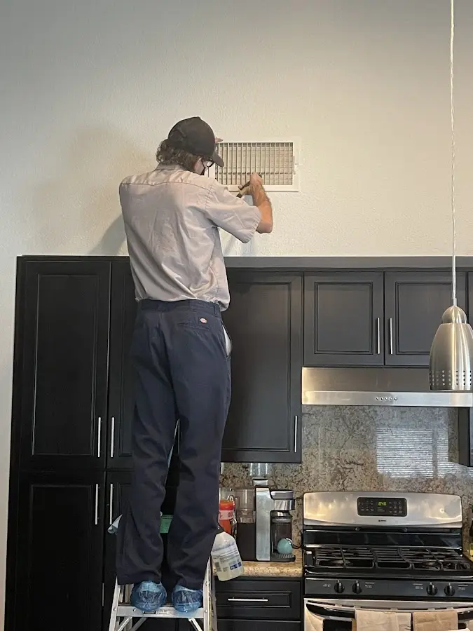 Technician inspecting an air vent during HVAC service in Waverly
